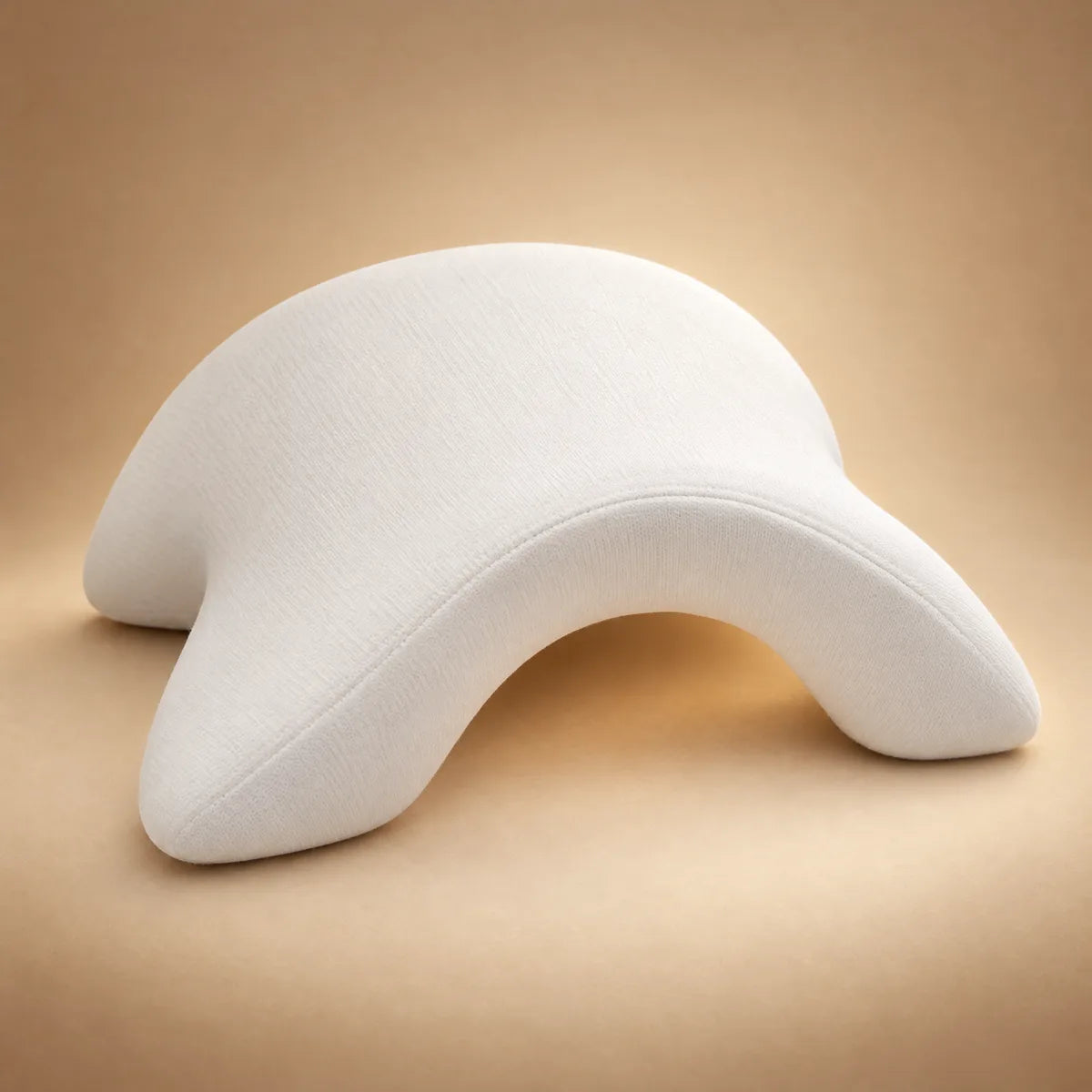 The white Cuddo pillow in three-quarter view, showing the arch and the arm tunnel